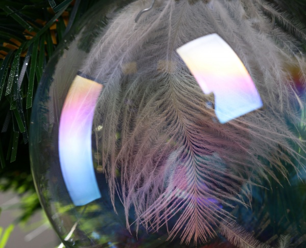 Елочная игрушка в форме шара прозрачная с перьями 8 см 