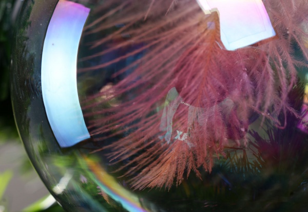 Елочная игрушка в форме шара прозрачная с перьями 8 см 